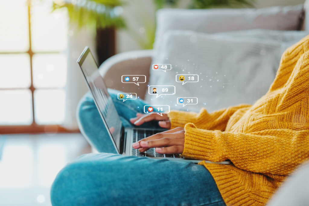 Persona gestionando campañas publicitarias desde una laptop, con interacciones en redes sociales como Meta, TikTok, Pinterest y Google, enfocadas en la optimización de anuncios para emprendedores y empresas.